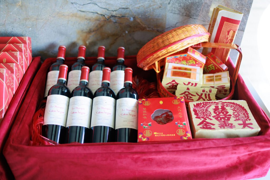 A red velvet tray of Taiwanese betrothal gifts — wine, joss paper and double happiness boxes
