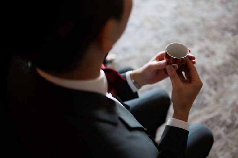 A groom holds a red tea ceremony cup during a Taiwanese engagement ceremony
